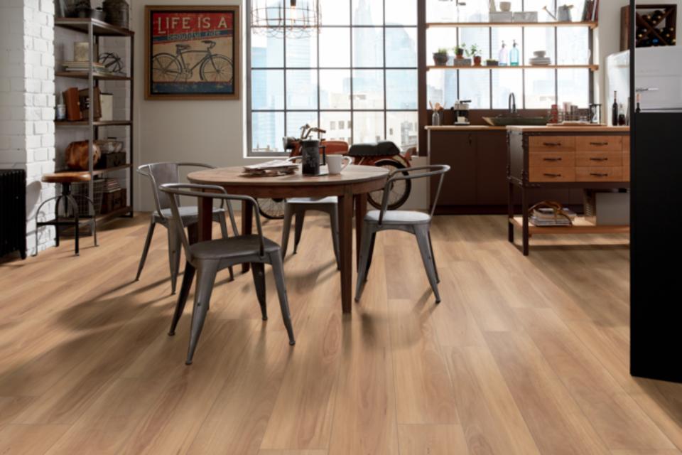 warm toned luxury vinyl plank flooring in kitchen with dining table and industrial decor.